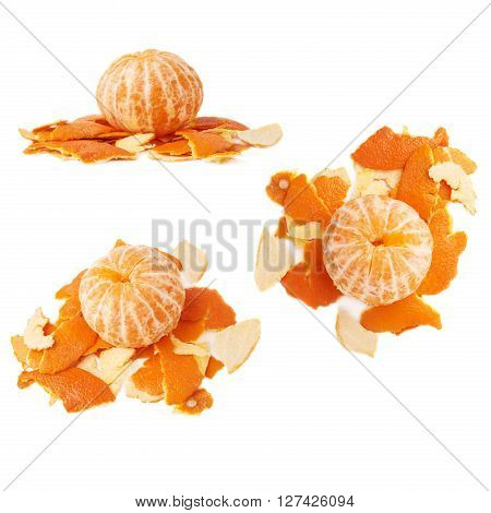 Unpealed cleaned fresh tangerine on a pile of it's peel isolated on white background