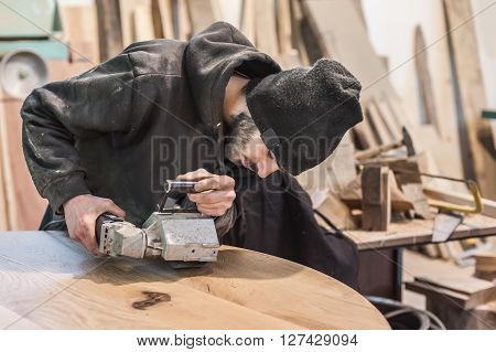Man doing woodwork in carpentry. Carpenter work on wood plank in workshop