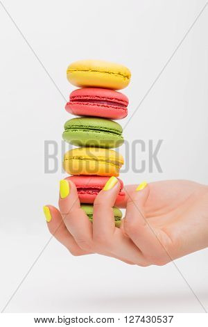 Person holding different color macaroons in her palm