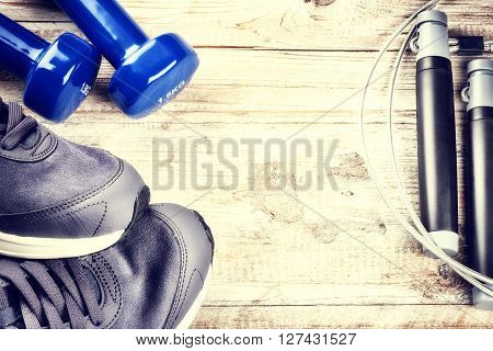 Fitness background with dumbbells sneakers and skipping rope. Healthy lifestyle concept with copy space