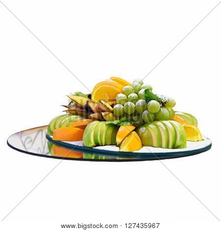 Delicious diet dish with slices of fruits on mirror base. Fruits isolated on a white background. Mix of fruits - oranges, apples and grapes. Useful vitamin food. The food is vegetarian and uses diet.