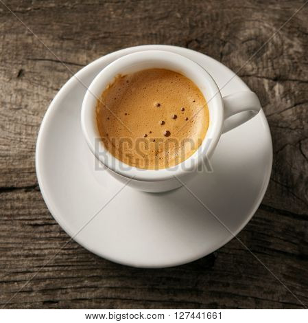 Cup of coffee espresso with foam on the old wooden background top view