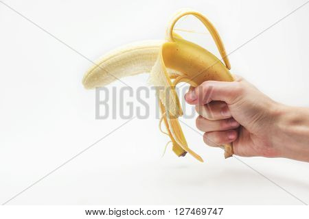 Banana fruit gun hold in caucasian white male hand over white background.