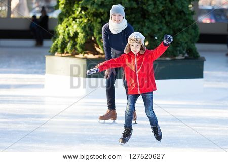 little boy learning ice skating and his mother watching and cheering up at outdoor skating rink having winter vacation fun
** Note: Soft Focus at 100%, best at smaller sizes