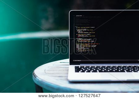laptop on a wooden table against the background of accepted Swimming pool