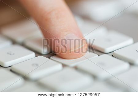 technology, programming, computing and people convept - close up of finger pressing button on computer keyboard