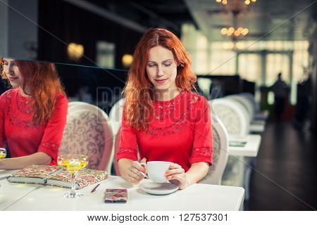 Beautiful  woman using 
laptop, phone at table in cafe