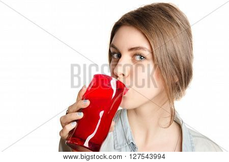 Young beautiful woman enjoying a healthy raw fruit juice. Studio shot.