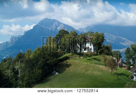 a white house on top of a hill at Piani d'Erna (part of the Alps) near Lake Como in Italy