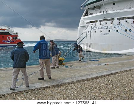 ISLAND OF MYKONOS, CYCLADES, GREECE - SEPTEMBER 12, 2009: Cruiser workers are pulling the ropes of giant cruiser ship Brilliance Of The Seas.