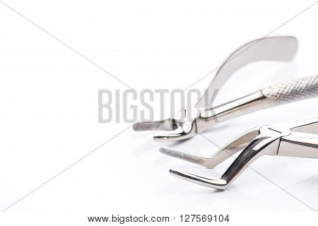 Two extraction forceps on a white surface
