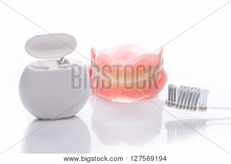 Teeth Model With Toothbrush And Dental Floss On White Background
