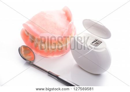 Teeth Model With Dental Floss And Mouth Mirror On White Background