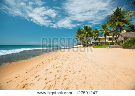 Tropical sandy beach with palm trees at sunny day. South of Bali, Jimbaran beach