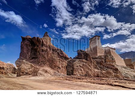 Ruins and Basgo Monastery surrounded with stones and rocks Blue sky with clouds in the background Himalayan Mountain range Leh Ladakh Jammu and Kashmir India