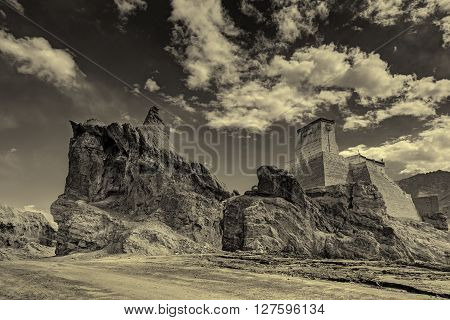 Ruins and Basgo Monastery surrounded with stones and rocks sky with clouds in the background Himalayan Mountain range Leh Ladakh Jammu and Kashmir India - tinted stock image of Indian monasteries