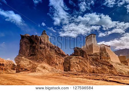 Ruins and Basgo Monastery surrounded with stones and rocks Blue sky with clouds in the background Himalayan Mountain range Leh Ladakh Jammu and Kashmir India