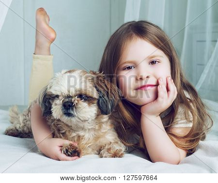 happy girl with her dog in bed at home