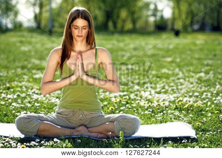 Young women practise yoga by day in nature
