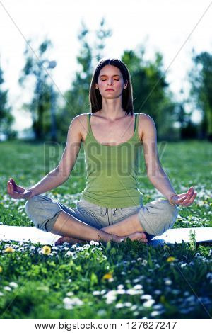 Young women practise yoga by day in nature