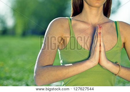 Young women practise yoga by day in nature