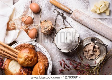 Baking ingredients - flour, butter, eggs, sugar. Baked flour-based food: bread, cookies, cakes, pastries, and pies. Top view.