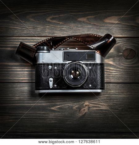 Retro film photo camera on the wooden background.