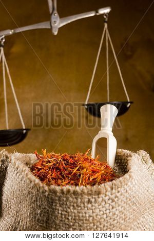 Saffron Spices in bag and scales on the wooden background