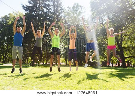 fitness, sport, friendship and healthy lifestyle concept - group of happy teenage friends or sportsmen jumping high outdoors