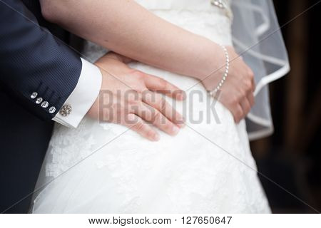 Unrecognisable groom holding his bride at waist heigth