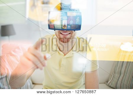 technology, multimedia, mass media, entertainment and people concept - happy young man in virtual reality headset or 3d glasses with media or web applications at home