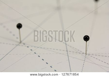 Black Pins In Paper Linked By Lines
