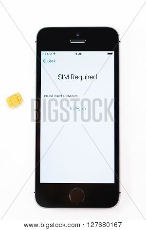 PARIS FRANCE - APR 21 2016: First start of the new iPhone SE with SIm required message on screen - the new phone combines the updated processor 4K rear camera touch id retina display