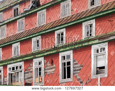 Broken windows in old devasted building. Detailed view of old mountain  lodge.