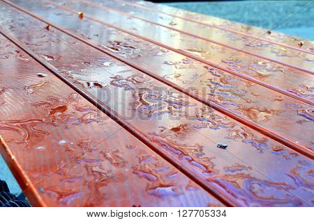 water drop on a wooden table outside after rainfall