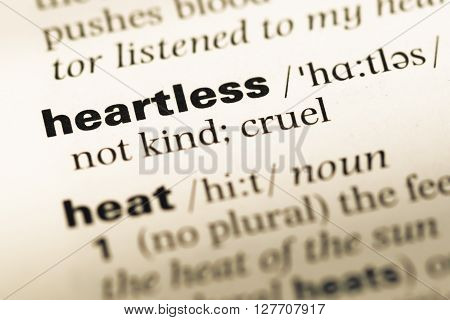 Close Up Of Old English Dictionary Page With Word Heartless.