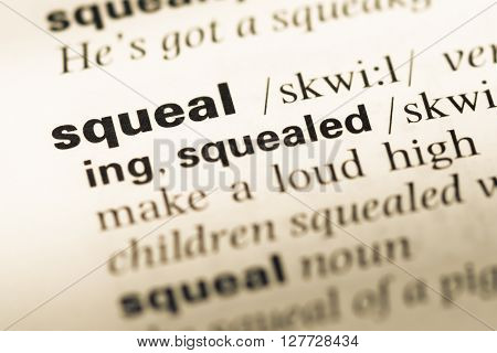 Close Up Of Old English Dictionary Page With Word Squeal.