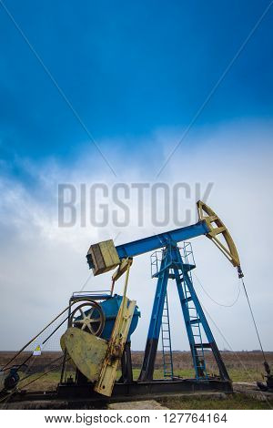 Sunset sky with profiled oil and gas well pump