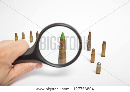 Magnifying glass and AK47 bullet close up