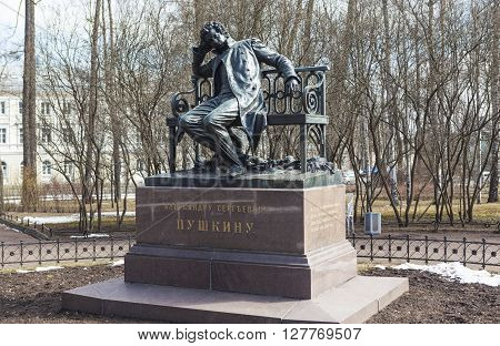 Tsarskoye Selo, Russia -April 16, 2016: Sculpture of a man in a cloak, sitting on a bench, on a high granite pedestal. The monument to Pushkin in Lyceum garden. Sculptor: P.P. Bach. Opened in 1899-1900 gg.