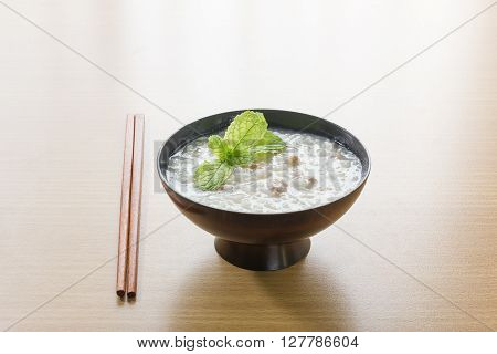 Traditional chinese rice gruel in bowl on wood table