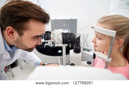 health care, medicine, people, eyesight and technology concept - optometrist with non contact tonometer checking patient intraocular pressure at eye clinic or optics store