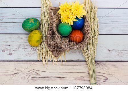 Easter morning: eggs  and yellow flowers on wood background