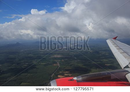 aerial top view from air plane see green field rural and wing aircraft engine clear white cumulus cloud and cloudscape on blue sky