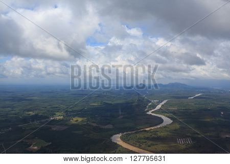 aerial top view from air plane see river and green hills field with clear white cumulus cloud and cloudscape on blue sky