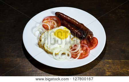 Fried eggs in a white plate  on wooden background