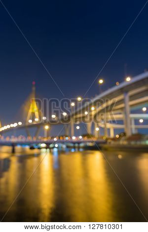 Blurred bokeh lights, suspension bridge and highway at twiligh