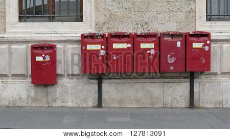SIENA ITALY - CIRCA APRIL 2016: row of old red letter box mailboxes for sending mail