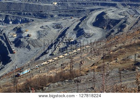huge quarry for the extraction of iron ore from moving train Gubkin Russian