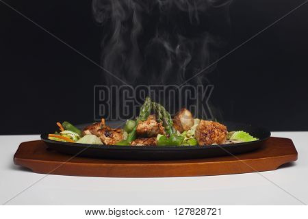 chicken meat with asparagus in a sizzler
